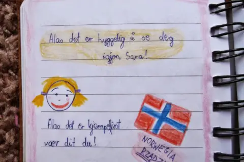 Złote myśli do pamiętnika dla dzieci: rysunek dziewczynki i flagi Norwegii. "Miło Cię znowu widzieć, Sara!" i "To jest super, że jesteś!".